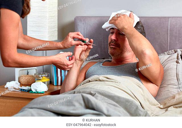 Sick man with flu and headache lying in bed