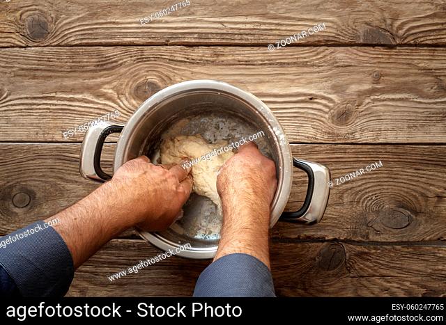 Man makes the dough in the pan on the table horizontal