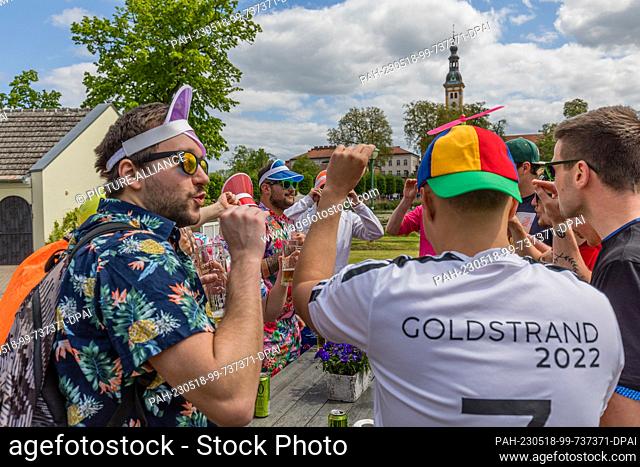 18 May 2023, Brandenburg, Neuzelle: Young men celebrate on Ascension Day in a restaurant at the Neuzelle Monastery. Ascension Day is a church holiday celebrated...
