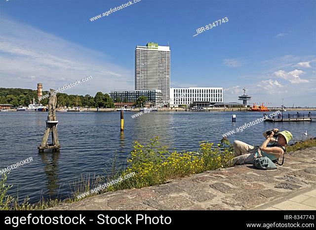 Woman lying on the ground and taking pictures, Fiete statue, Old Lighthouse, Hotel Maritim, Travemünde, Lübeck, Schleswig-Holstein, Germany, Europe