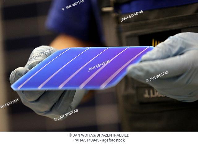 Joerg Liebscher, module production employee at Solarworld, presents a high-performance PERC solar cell, which holds the record with an efficiency rate of 22