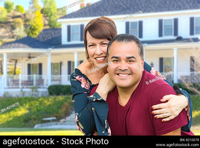 mixed-race young adult couple portrait in front of beautiful house