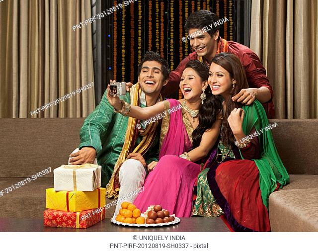 Friends taking a picture of themselves with a camera on Diwali