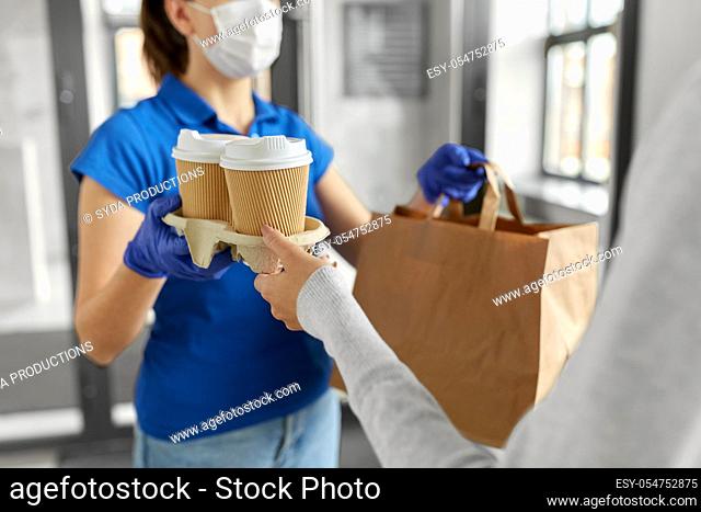delivery girl in mask giving paper bag to woman