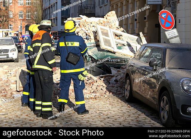 02 December 2021, Hamburg: Emergency services stand in front of a house whose facade has collapsed. Presumably due to an explosion or a deflagration