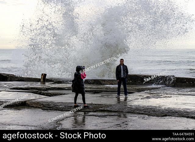 RUSSIA, SOCHI - NOVEMBER 13, 2023: A man poses for a photograph during a storm on the Black Sea, in the Adler neighbourhood. Dmitry Feoktistov/TASS