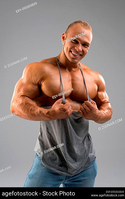 Happy muscular bodybuilder with thick metal chain on his neck cropped shot