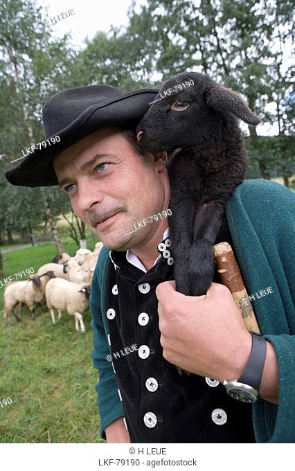 Shepherd with black lamb on his shoulder, Rhoen Sheep, Schaeferei Weckbach, Ehrenberg Wuestensachsen, Rhoen, Hesse, Germany