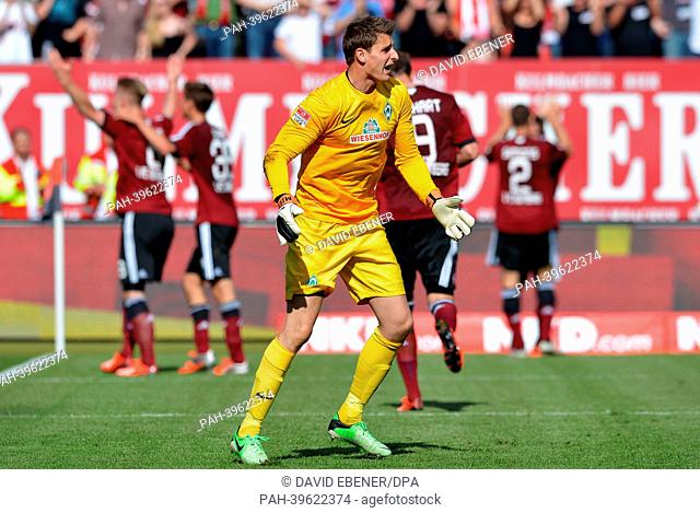 Bremen's keeper Sebastian Mielitz shouts after the 2-1 goal for Nuremberg, while the goal scorer Sebastian Polter (L) cheers during the Bundesliga soccer match...