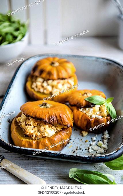 Pumpkins stuffed with couscous and feta, garnished with basil