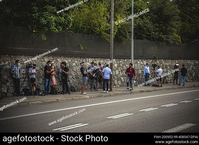 02 September 2020, Spain, Barcelona: Journalists and photographers wait for the father of football star Messi in front of his apartment in Barcelona