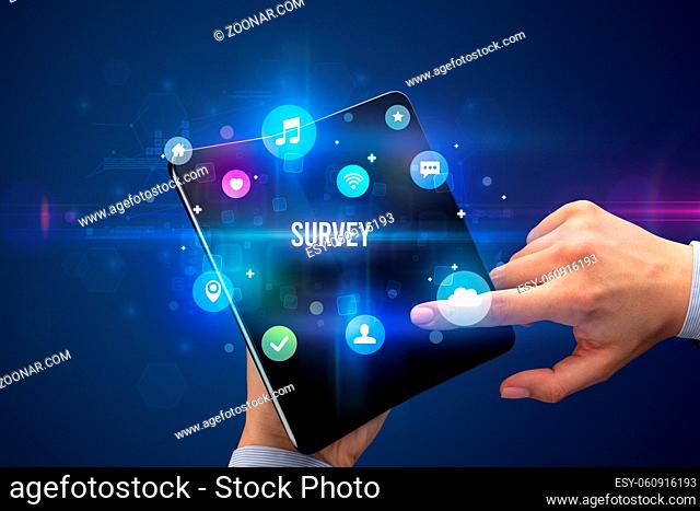 Businessman holding a foldable smartphone with SURVEY inscription, social media concept
