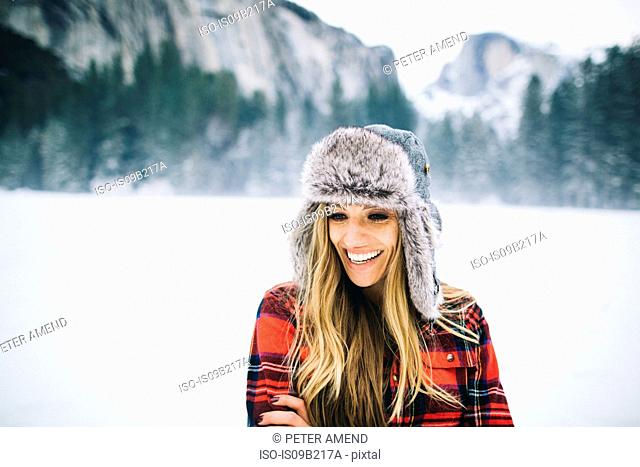 Rear view of woman wearing ushanka hat on snow-covered landscape