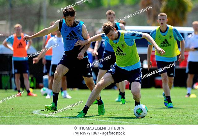 Per Mertesacker (R) and Heiko Westermann vie for the ball during the training of the German national team on the grounds of the Barry University in Miami, USA
