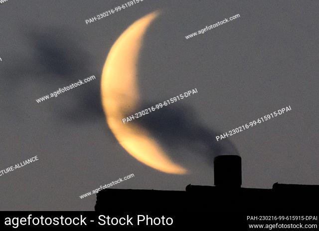 16 February 2023, Lower Saxony, Laatzen: Steam from a heating system rises from the roof of a detached house in the Hanover region in front of the crescent moon