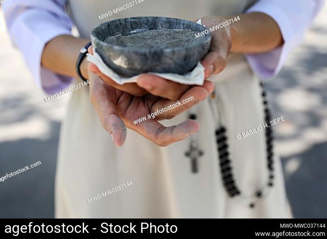 A nun holds a small bowl containing ash to be sprinkled on the heads of Catholic devotees during an Ash Wednesday mass at the Redemptorist church in Baclaran