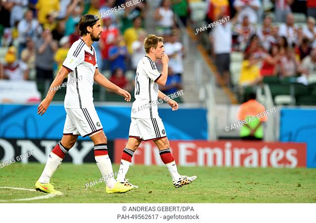 Germany's Sami Khedira (L) and Philipp Lahm react during the FIFA World Cup 2014 group G preliminary round match between Germany and Ghana at the Estadio...
