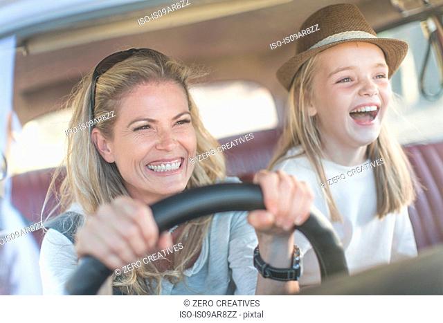 Mother and daughter in car together, smiling