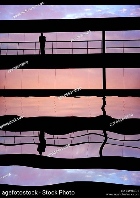 worker inside the building silhouette at sunset