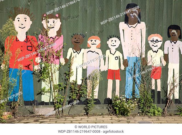 Painted collage picture of young children on a nursery school fence, Wickham Market, Suffolk, England