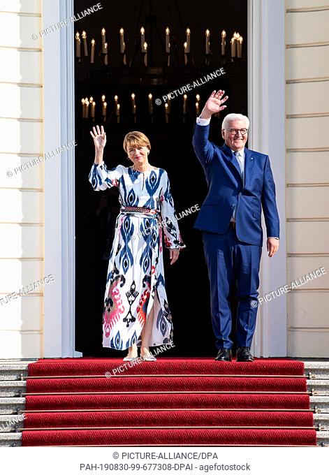 30 August 2019, Berlin: Federal President Frank-Walter Steinmeier and his wife Elke Büdenbender wave to welcome the guests of the Bürgerfest in the park of...