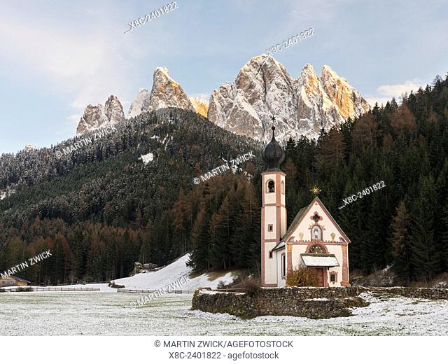 The peaks of the Geisler mountain range (Gruppo delle Odle) in valley Villnoess during autumn. The church Sankt Johann in Ranui (St. John in Ranui)
