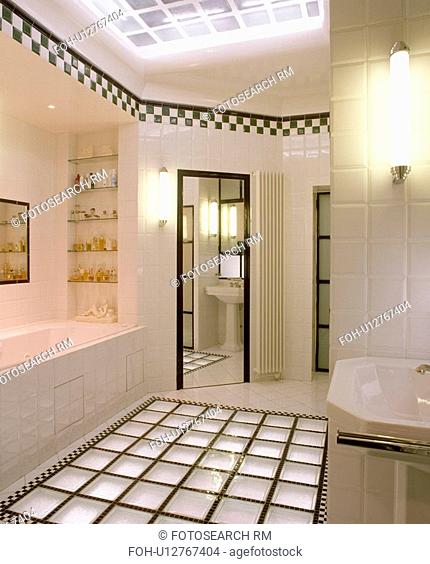 Glass brick flooring in modern white tiled bathroom with black+white chequerboard tiling border below ceiling&13, &10