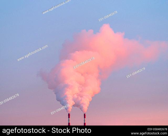Smoke from chimneys of heating plant. Air pollution. Factory pipes with smoke, frosty weather, sunrise. Ecology problem