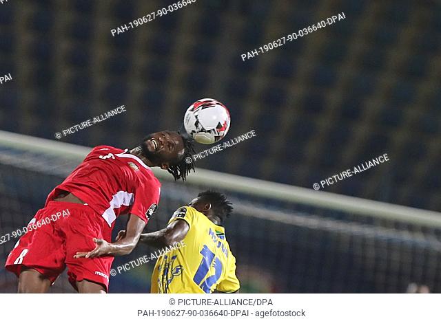 27 June 2019, Egypt, Cairo: Kenya's Johanna Omolo (L) and Tanzania's Happygod Msuvan battle for the ball during the 2019 Africa Cup of Nations Group C soccer...