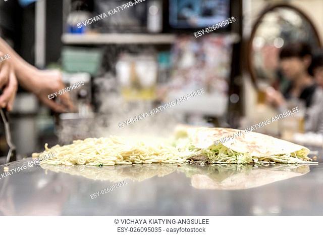 cooking of okonomiyaki japanese pizza