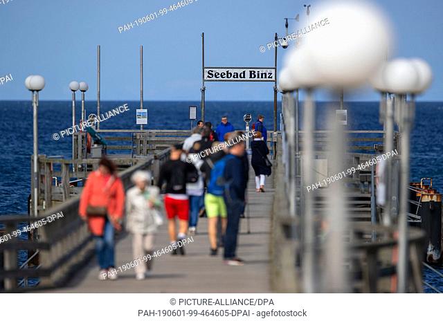 28 May 2019, Mecklenburg-Western Pomerania, Binz: Holidaymakers cross the sea bridge of Binz which celebrates its 25th anniversary this year