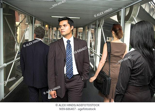 Businessman walking against the flow of other business people