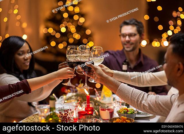 happy friends drinking wine at christmas party