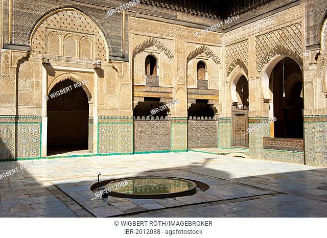 Courtyard of the Koran school, Madrasa Bou Inania, with wash fountains, walls and arches with carved cedar wood, stucco ornaments and tiled mosaics, Fez