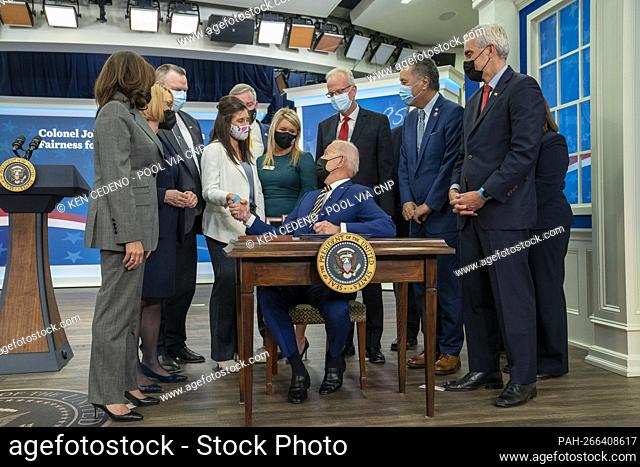 President Joe Biden shakes hands with Kelly McHugh-Stewart before signing a law named after her father, S.1095, ""Colonel John M