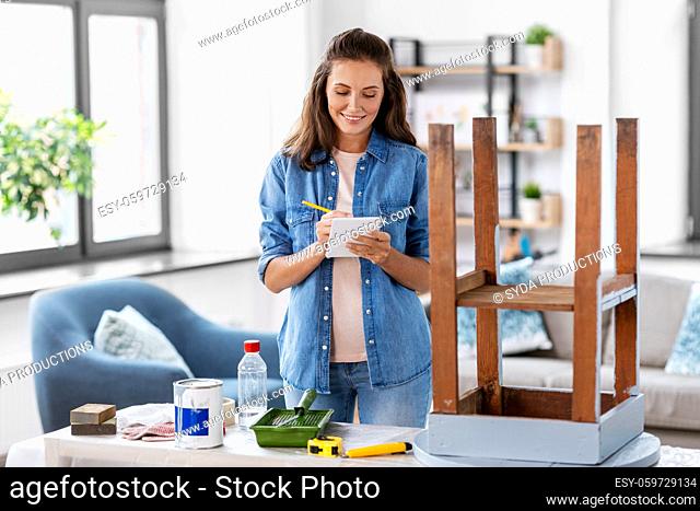 woman with old table writing to notebook at home