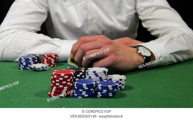 Poker player winning the pot with a pair of tens