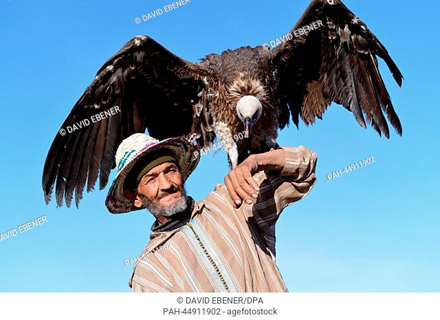 An elderly Moroccan man lets himself be photographed with a vulture on Place Jemaa El Fna in Marrakesh, Morocco, 19 December 2013