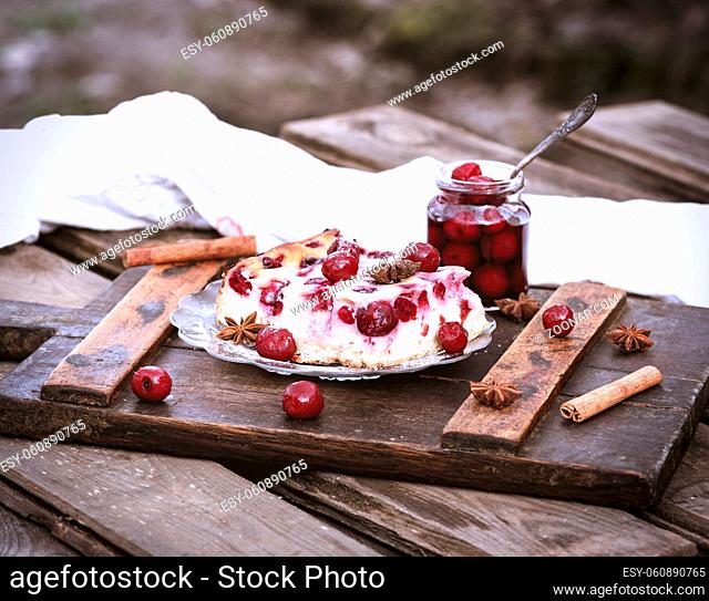 piece of cottage cheese cake and cherry berries on a glass plate and canned cherry berries