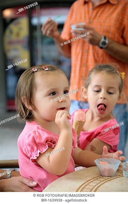 Two girls sitting in an ice cream parlour