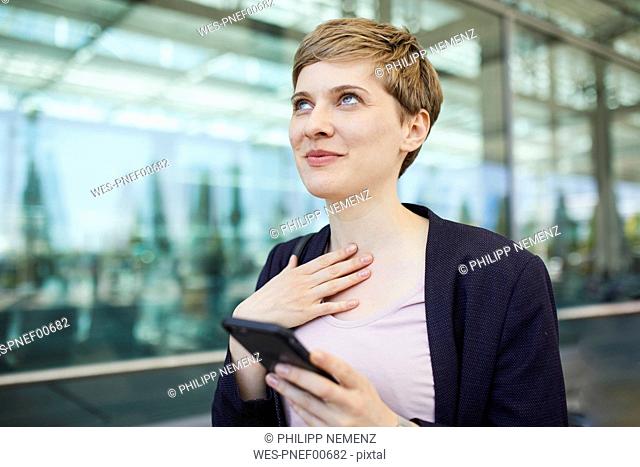 Portrait of blond businesswoman using smartphone