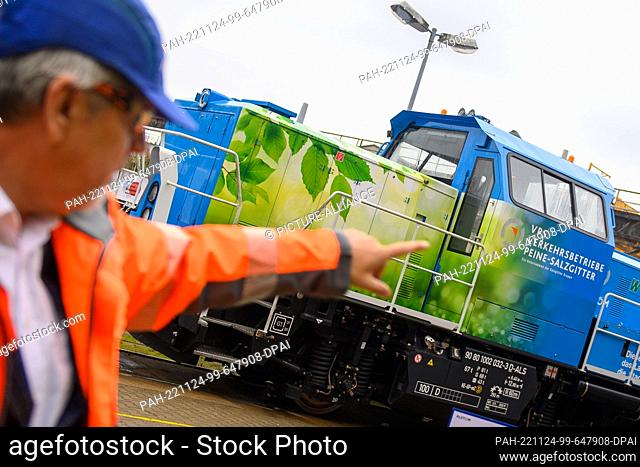 24 November 2022, Saxony-Anhalt, Stendal: Jörg Neubauer, plant manager at Alstom's Stendal site, points to a hydrogen-powered shunting locomotive