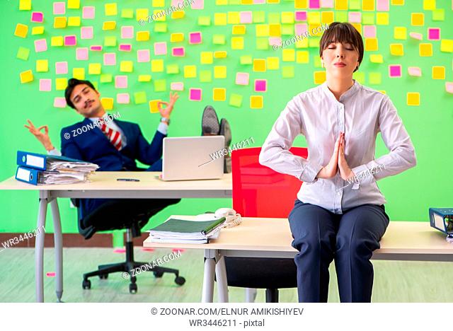 Man and woman in the office with many conflicting priorities in yoga concept