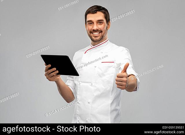 happy male chef with tablet pc showing thumbs up