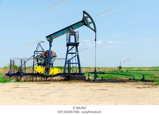 Oil Well Machine in Field on Clear Sunny Day, horizontal shot