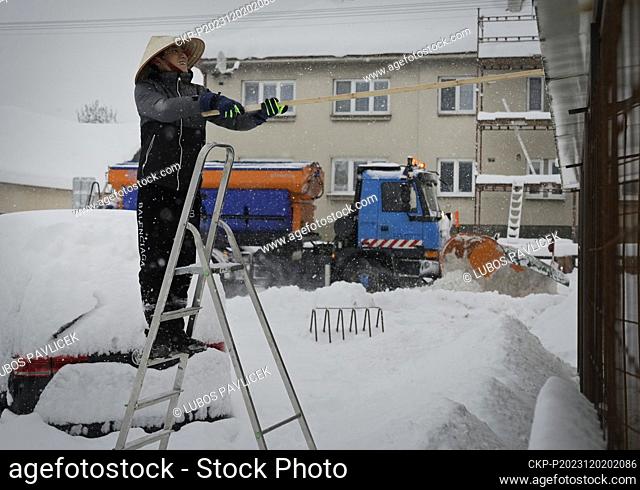 A Vietnamese shopkeeper removes snow from his shop in Kostelec u Jihlavy, Jihlava region, Czech Republic, December 2, 2023. (CTK Photo/Lubos Pavlicek)