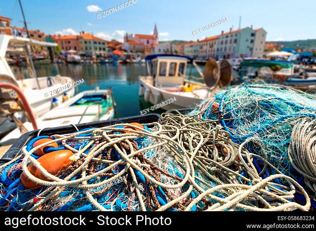 Scenic harbour with boats and brightly coloured houses on the fishing net waterfront in Izola - Isola