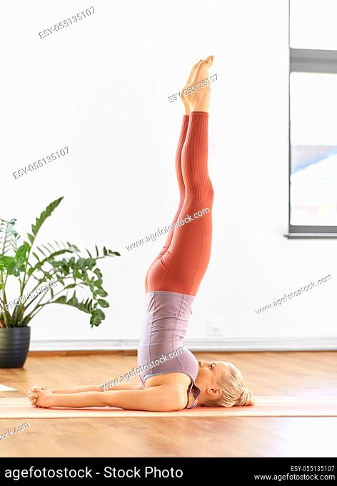 woman doing yoga in shoulderstand at home
