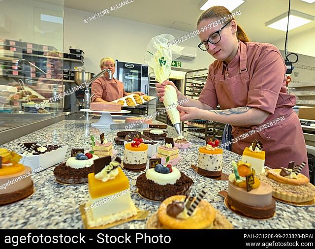 08 December 2023, Brandenburg, Fürstenwalde: Michelle Thiede, pastry chef, makes small handmade cakes for the opening of the Le Gateau rose cake factory