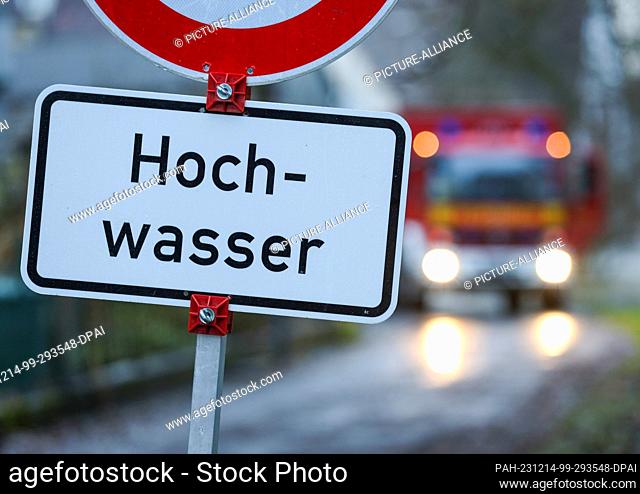 14 December 2023, Baden-Württemberg, Riedlingen: A fire department emergency vehicle stands behind a sign reading ""Flood""